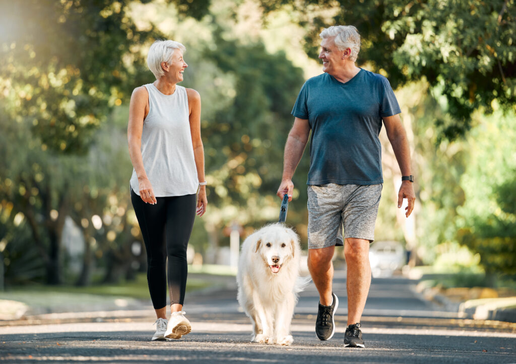 Elderly couple walking their dog