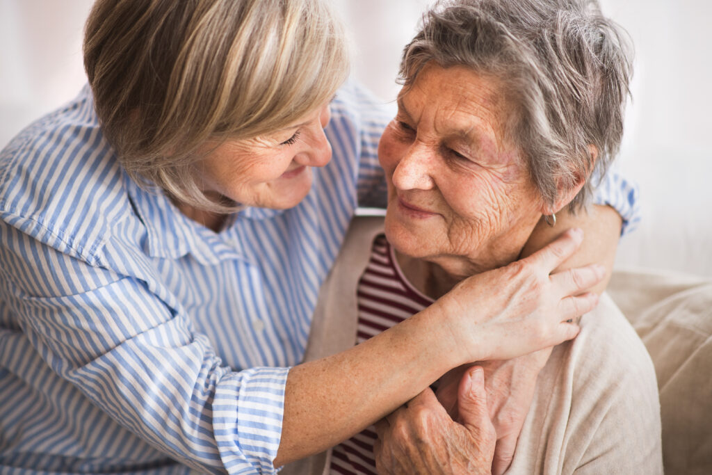 Daughter hugging elderly mother